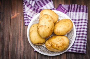 Çiğ patates kahverengi ahşap arka plan üzerinde