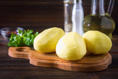 RAW soyulmuş ve dilimlenmiş patates üzerinde eski yıpranmış ahşap masa