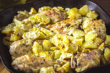 Kimyon ve sarımsak ile patates ile kavrulmuş tavuk budu.