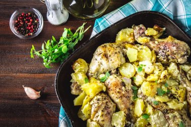 Kimyon ve sarımsak ile patates ile kavrulmuş tavuk budu.