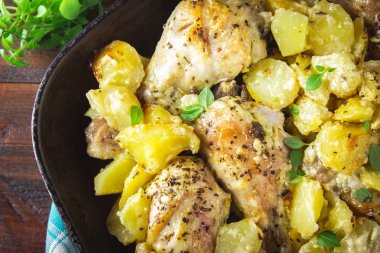 Kimyon ve sarımsak ile patates ile kavrulmuş tavuk budu.
