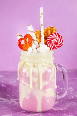 Pembe yüzlü, krem üzerinden Freakshake. Lolipop, waffle ve hatmi ile Monstershake. Bir Mason kavanoza aşırı milkshake. Mor pembe.