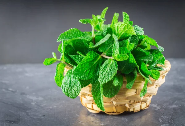 Yeşil gri bir arka plan üzerinde bir sepet içinde nane
