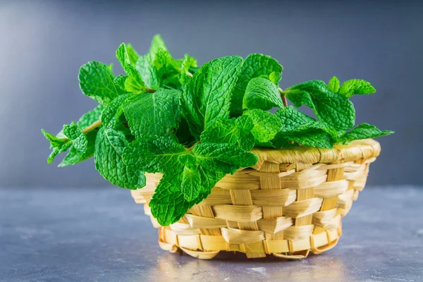 Yeşil gri bir arka plan üzerinde bir sepet içinde nane