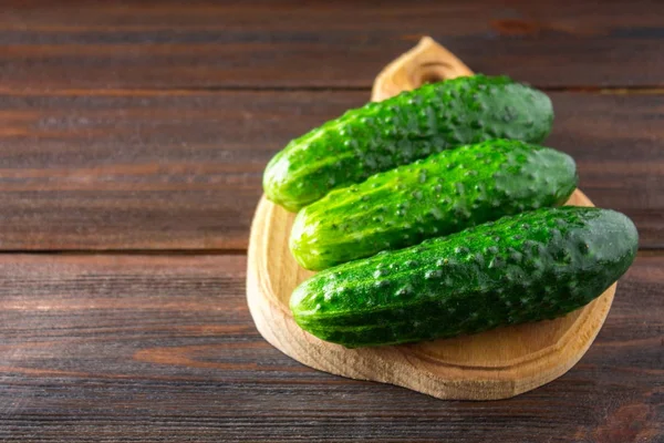 Fresh raw green cucumbers on a wooden table — Stock Photo, Image