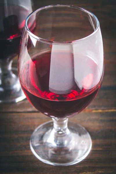 Two glasses of red wine on a brown wooden table. Alcoholic beverages. — Stock Photo, Image