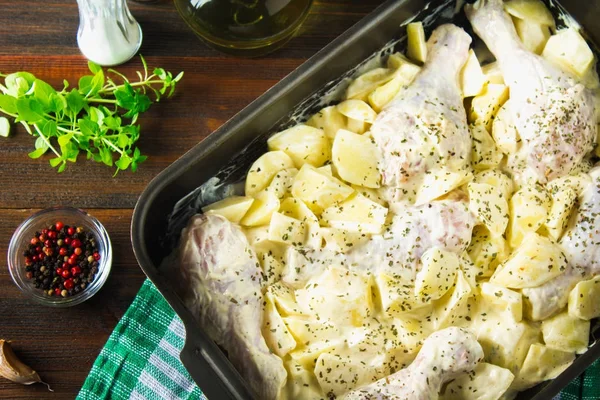 Çiğ tavuk budu mayonez üzerinde ahşap bir masa pişirme için formunda ham patates ile. Et yemek pişirmek için malzemeler. Tarifi. Üstten Görünüm.