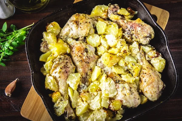 Kimyon ve sarımsak ile patates ile kavrulmuş tavuk budu.