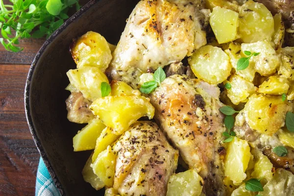 Kimyon ve sarımsak ile patates ile kavrulmuş tavuk budu.