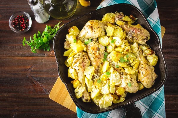 Kimyon ve sarımsak ile patates ile kavrulmuş tavuk budu.