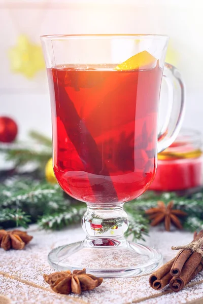 New Year's mulled wine in a glass on the background of twigs, candles and garlands. — Stock Photo, Image