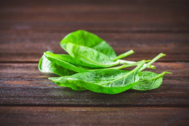 Ahşap bir masa üzerinde yeşil taze ıspanak yaprakları