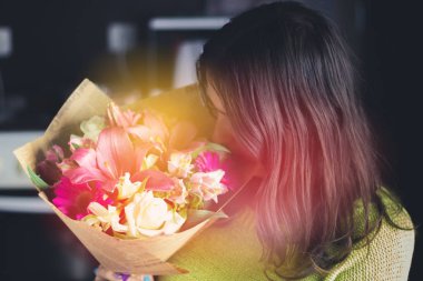 Bir buket çiçek bir zambak, gerbera, beyaz gül ve alstroemeria koyu arka plan üzerinde siyah saçlı güzel kız. Bir tatil, bir hediye.
