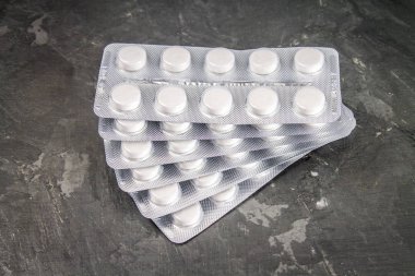 Kabarcıklar gri beton zemin üzerine beyaz hap.