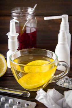 Sağlık, geleneksel tıp ve grip kavramı - çay limon, termometre ve ahşap masa uyuşturucu