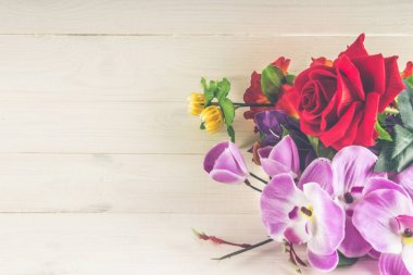 Beyaz ahşap zemin üzerinde yapay çiçekler