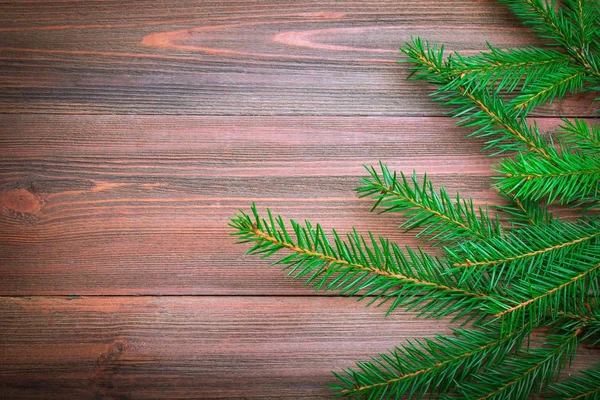 Rama de árbol de Navidad sobre un fondo de madera — Foto de Stock