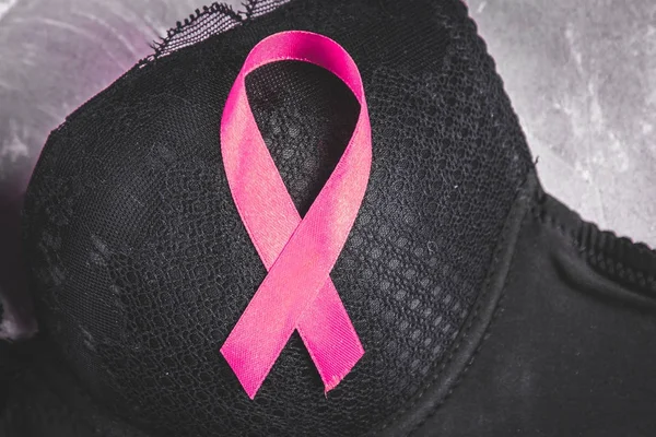 Awareness of breast cancer on a black bra on a pink background