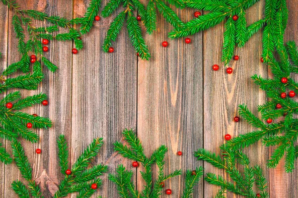 Spruce branches with red berries on a wooden table. copy space. — Stock Photo, Image