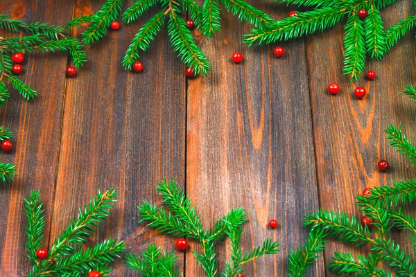 Spruce branches with red berries on a wooden table. copy space. — Stock Photo, Image