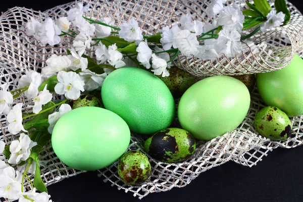 Oeufs de Pâques verts couchés sur du tissu blanc avec des fleurs — Photo