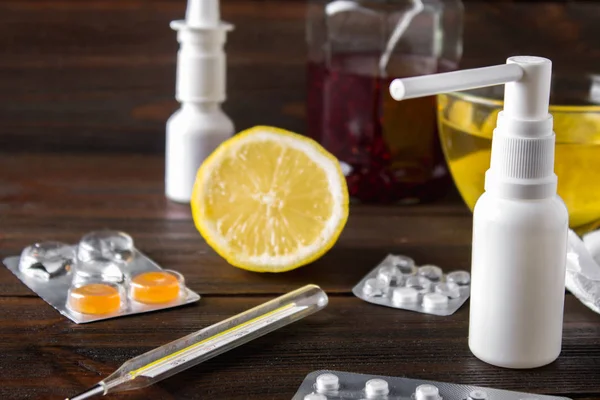 Médicaments contre le rhume - pilules, spray. Remèdes populaires - citron, thé, confiture de framboises. Thermomètre, mouchoirs. Traitement de la maladie, grippe . — Photo