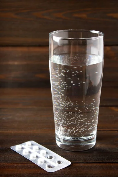 Bir bardak su masada yanında tablet yalan. Hastalığı, grip, soğuk. Tedavi, ilaç. — Stok fotoğraf