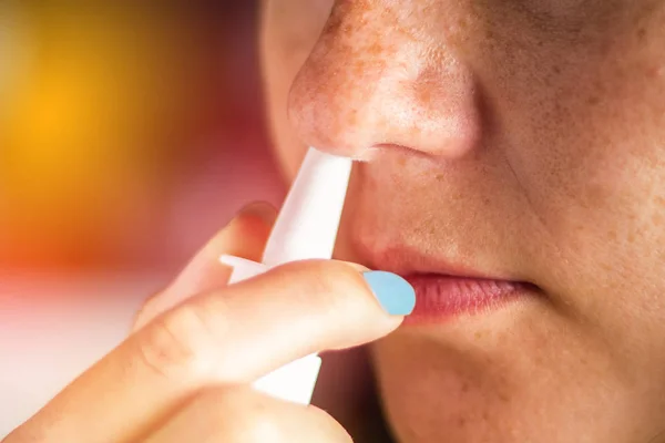 La chica usa un spray para la nariz. Tratamiento de resfriados, gripe . — Foto de Stock