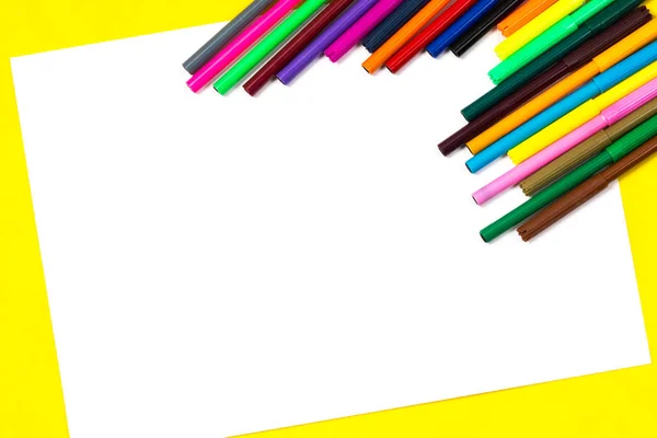 School leveringen en wit vel op een helder gele achtergrond, klaar voor uw ontwerp — Stockfoto