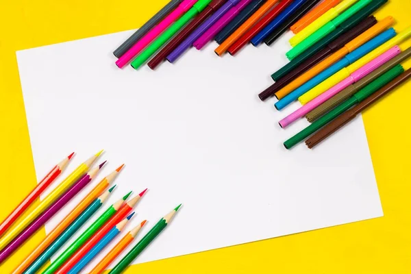 Material escolar y sábana blanca sobre un fondo amarillo brillante, listo para su diseño —  Fotos de Stock