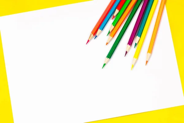 School leveringen en wit vel op een helder gele achtergrond, klaar voor uw ontwerp — Stockfoto
