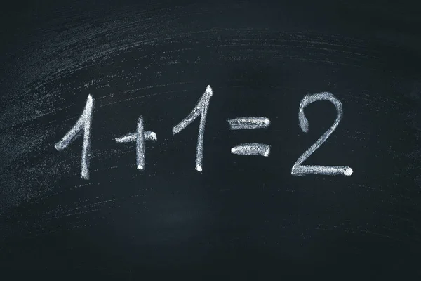 Equação simples de matemática em giz. Um mais um é igual a dois — Fotografia de Stock