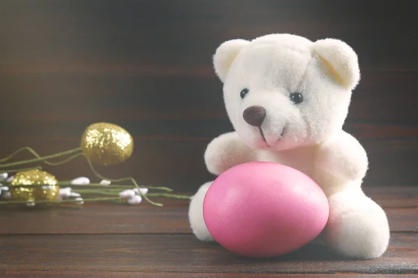 Teddy beer houdt een Easter egg, kip, houten achtergrond Rechtenvrije Stockfoto's