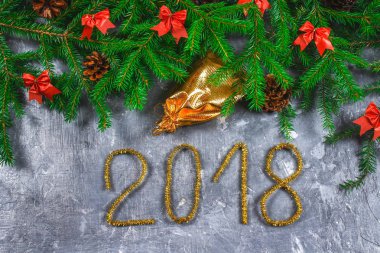 Çam dalları koniler ve gri beton zemin üzerine kırmızı yay ile. Yeni yıl Noel. Metin 2018 of altın gelin teli.