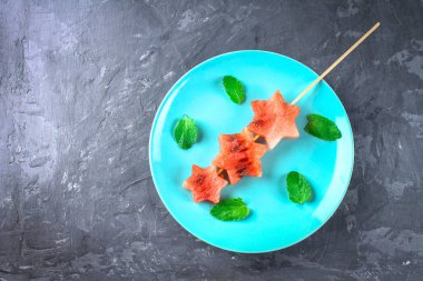 Karpuz nane yaprakları ile şiş üzerinde yıldız şeklinde bir mavi plaka üzerinde yatıyor. Üstten Görünüm.