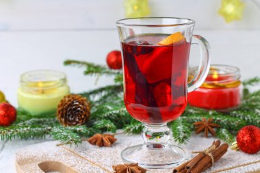 Dal, arka planda bir bardak içinde yeni yıl mulled şarap ve mumlar çelenk.