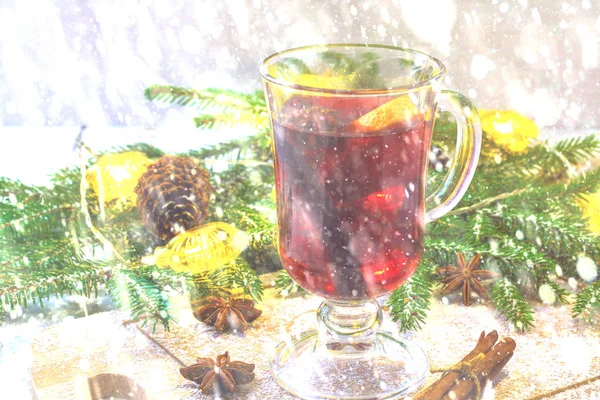 新年のホットワイン、小枝の背景にあるガラスのキャンドルし、花輪. — ストック写真