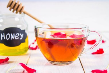 Çiçek siyah çay, bal olabilir, bir beyaz tahta masada yaprakları.