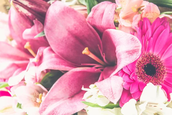 Un ramo de flores de un lirio, gerberas, rosas blancas y alstroemeria en una mesa de madera blanca. Unas vacaciones, un regalo . — Foto de Stock