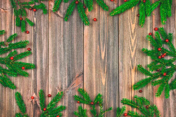 Las ramas de abeto con bayas rojas en una mesa de madera. espacio de copia . —  Fotos de Stock