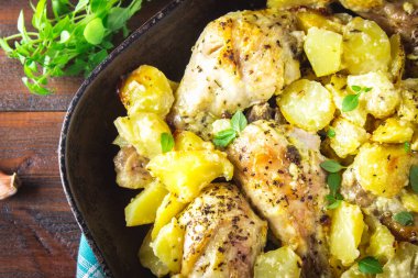 Kimyon ve sarımsak ile patates ile kavrulmuş tavuk budu.