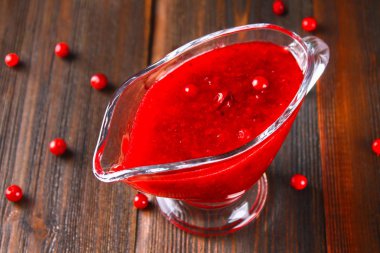 Fuska kızılcık sosuna çam dalları ile ahşap bir masa üzerinde bir cam temiz daire.