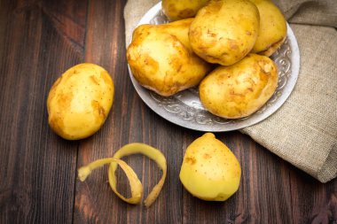 Çiğ patates kahverengi ahşap arka plan üzerinde.