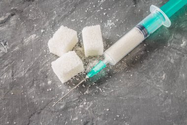 Bir şırıngada şekerim. Tatlı olan bağımlılığını kavramsal gösterimi. Şeker bir ilaçtır. Enjeksiyon tatlılar.
