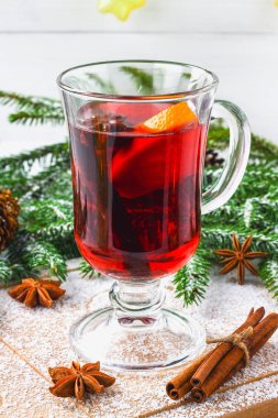 Dal, arka planda bir bardak içinde yeni yıl mulled şarap ve mumlar çelenk.