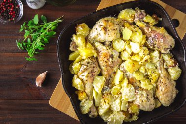 Kimyon ve sarımsak ile patates ile kavrulmuş tavuk budu.