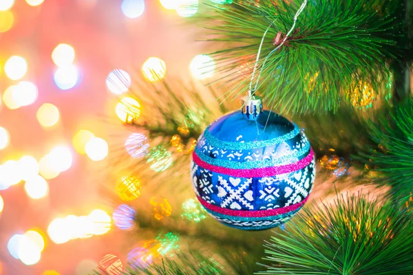 Palla azzurra di Natale su un albero di Natale su uno sfondo di ghirlande di luci, bokeh . — Foto Stock