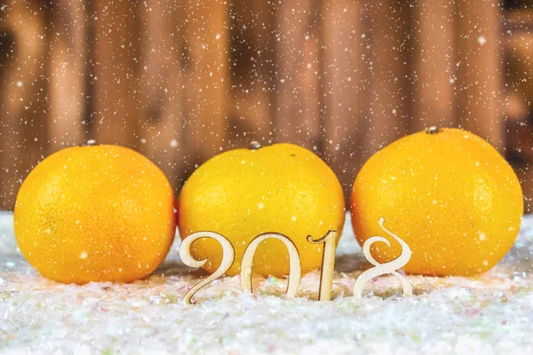 Holzfiguren des Jahres 2018 auf Schnee. Weihnachtsstimmung. das neue jahr 2018. mandarins. — Stockfoto