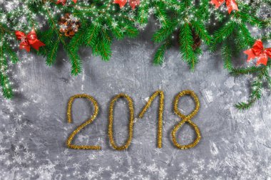 Çam dalları koniler ve gri beton zemin üzerine kırmızı yay ile. Yeni yıl Noel. Metin 2018 of altın gelin teli.