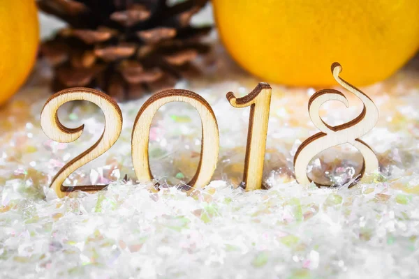 Houten figuren van 2018 op sneeuw. Kerstsfeer. Het nieuwe jaar 2018. Mandarijnen en kegels. — Stockfoto